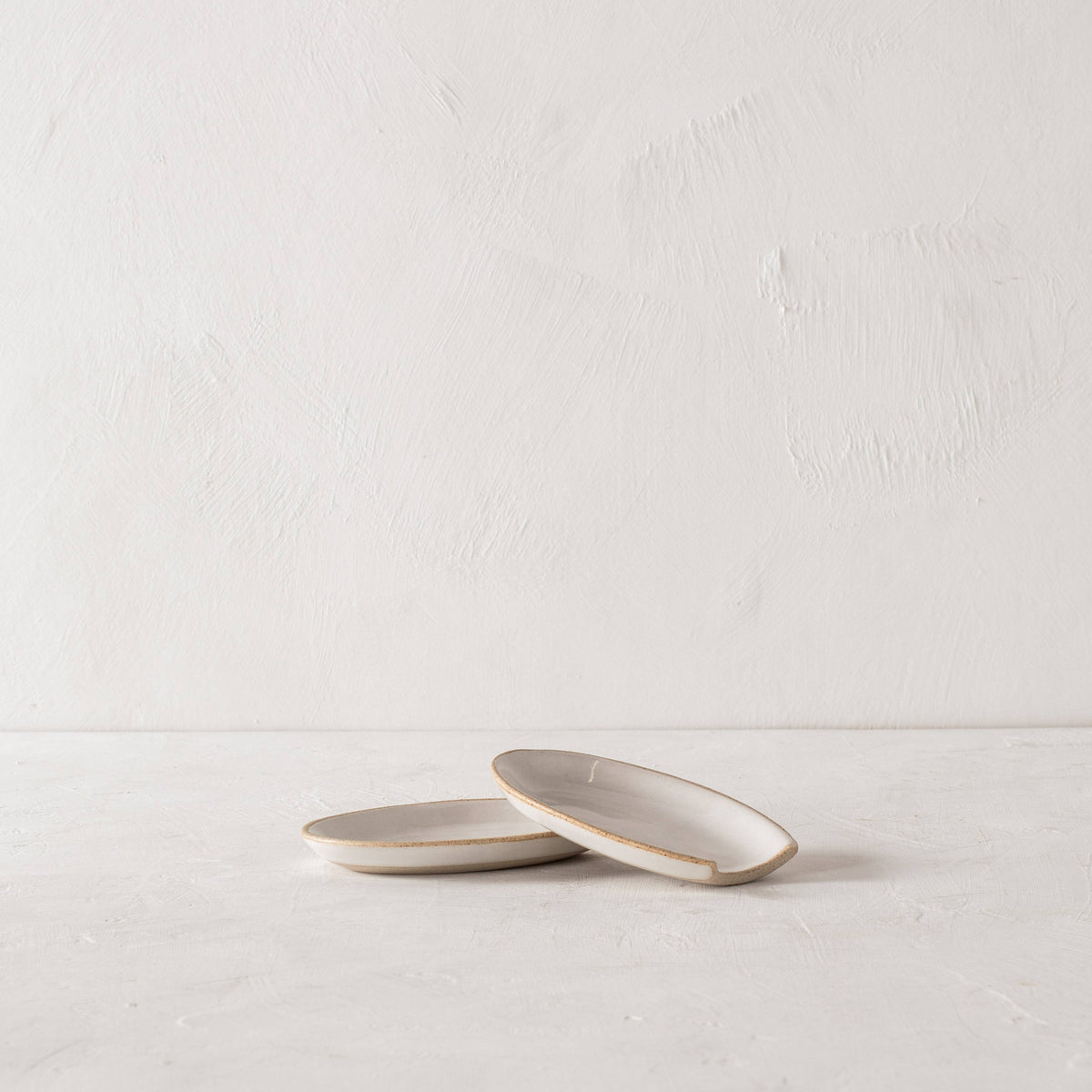 Minimalist designed spoon rests made of sand clay with an ivory glaze.