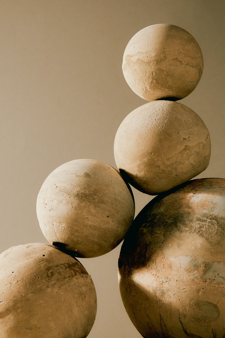Neutral tone marble spheres balancing together. Home decor trends of 2023.