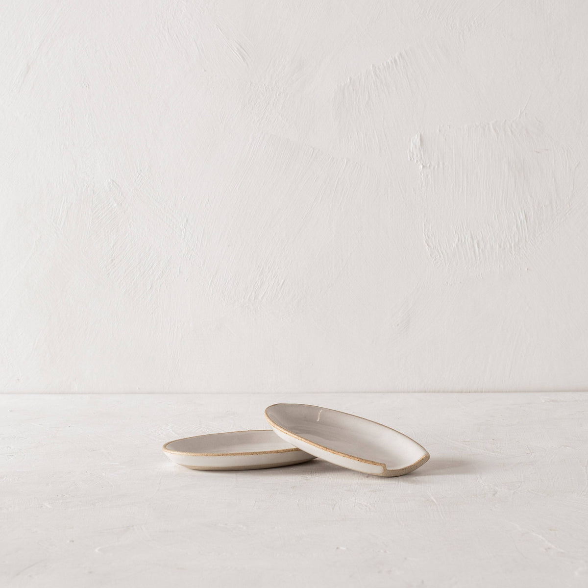Minimalist designed spoon rests made of sand clay with an ivory glaze. 