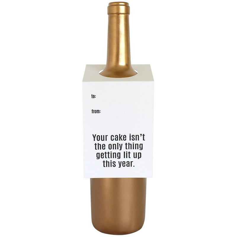 Your cake isn't the only thing getting lit up this year wine and spirit tag on a gold bottle on white paper with black text.